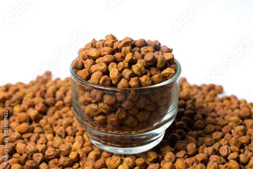 Fototapeta Horizontal shot of Organic Brown Chickpeas in a Glass Bowl Isolated on a white background