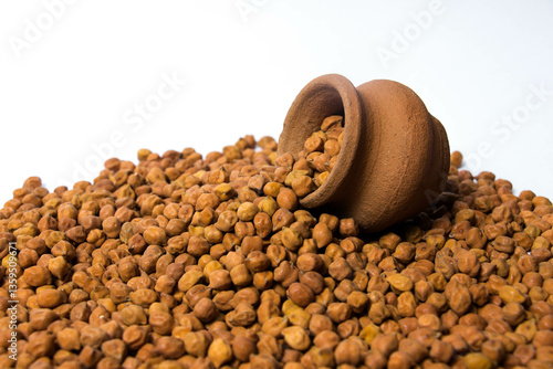 Fotografie Organic Brown Chickpeas in a earthen clay pot Isolated on a white background