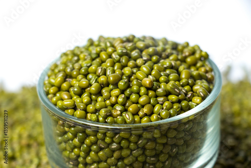 Fototapeta Closeup of Green Moong Dal beans in a Glass Bowl Isolated on a white background