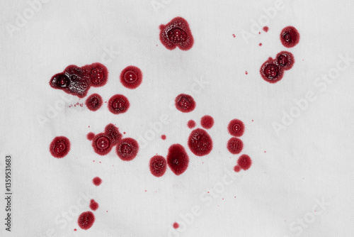 Drops of blood stains on white fabric. blood splatters on clothes. red dripping blood spatters