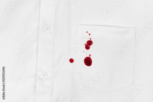 Drops of blood stains on white shirt with a pocket. red dripping splatters on white fabric. blood splatters on clothes.