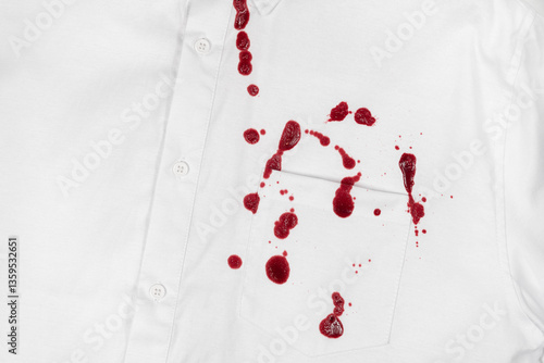 Drops of blood stains on white shirt with a pocket. red dripping splatters on white fabric. blood splatters on clothes.