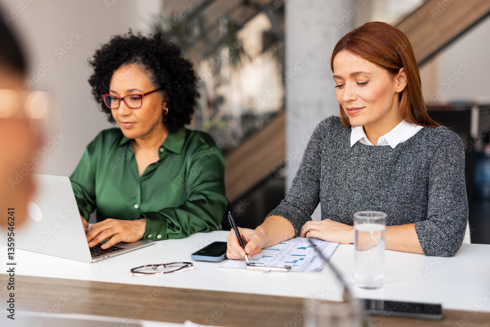 Two Businesswomen Collaborating at an Office Desk