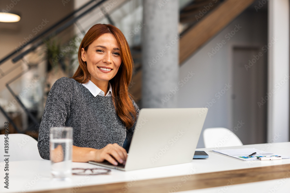 Confident Professional Woman Working at Laptop in Modern Office Setting