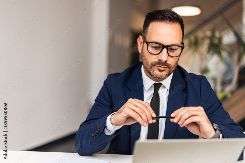 Businessman in a Suit Working at a Desk in a Modern Office