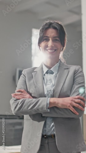 Wallpaper Mural Confident Caucasian woman in gray blazer standing in industrial facility. Professional leader dressed in light blue shirt with arms crossed. Smiling warmly while looking directly at camera. Torontodigital.ca