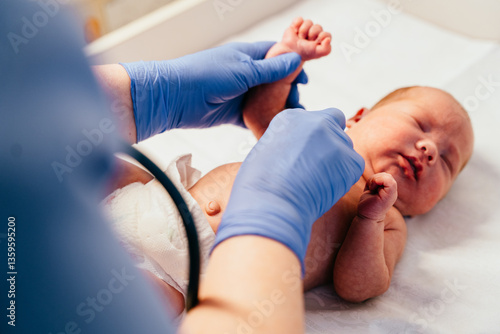 Φωτογραφία Nurse in gloves checking newborn baby foot reflexes