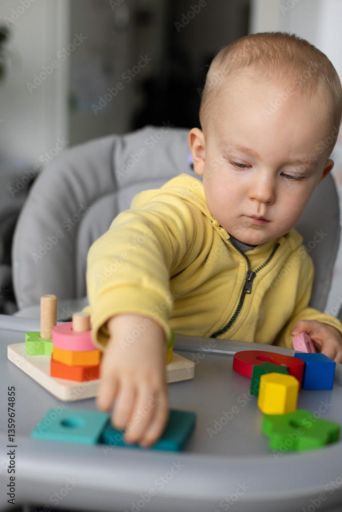 Baby is busy with educational toy, Cognitive skills, Montessori activity. Closeup, selective focus. Baby is busy with educational toy, Cognitive skills, Montessori activity. Closeup, selective focus.