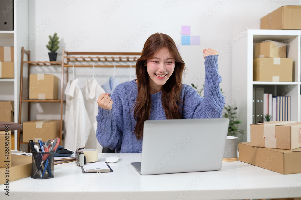 Successful small business owner celebrating online sales while looking at her laptop. E-commerce success and digital business concept. Successful small business owner celebrating online sales while looking at her laptop. E-commerce success and digital business concept.