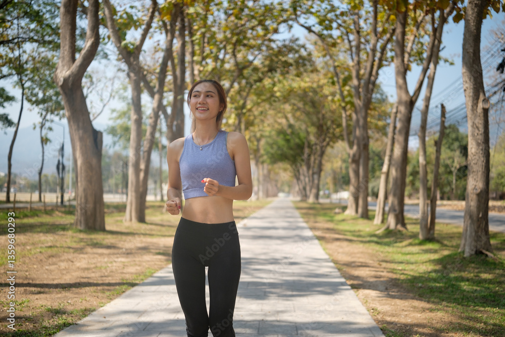 Beautiful woman jogging along a peaceful park pathway. Fitness and healthy lifestyles concept. Beautiful woman jogging along a peaceful park pathway. Fitness and healthy lifestyles concept.