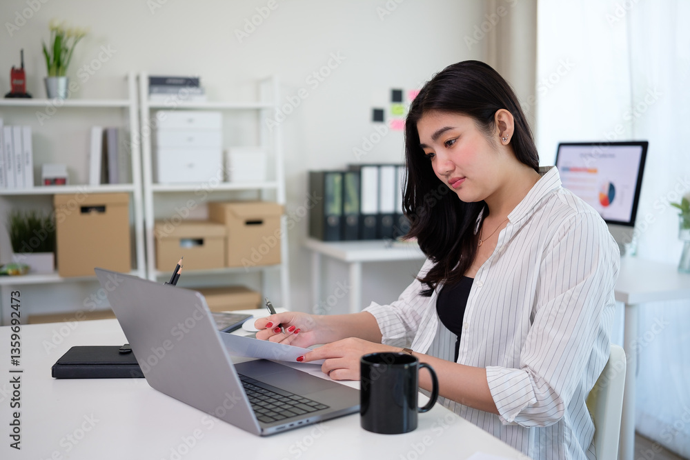Focused young entrepreneur using laptop and analyzing financial reportsat her desk. Focused young entrepreneur using laptop and analyzing financial reportsat her desk.