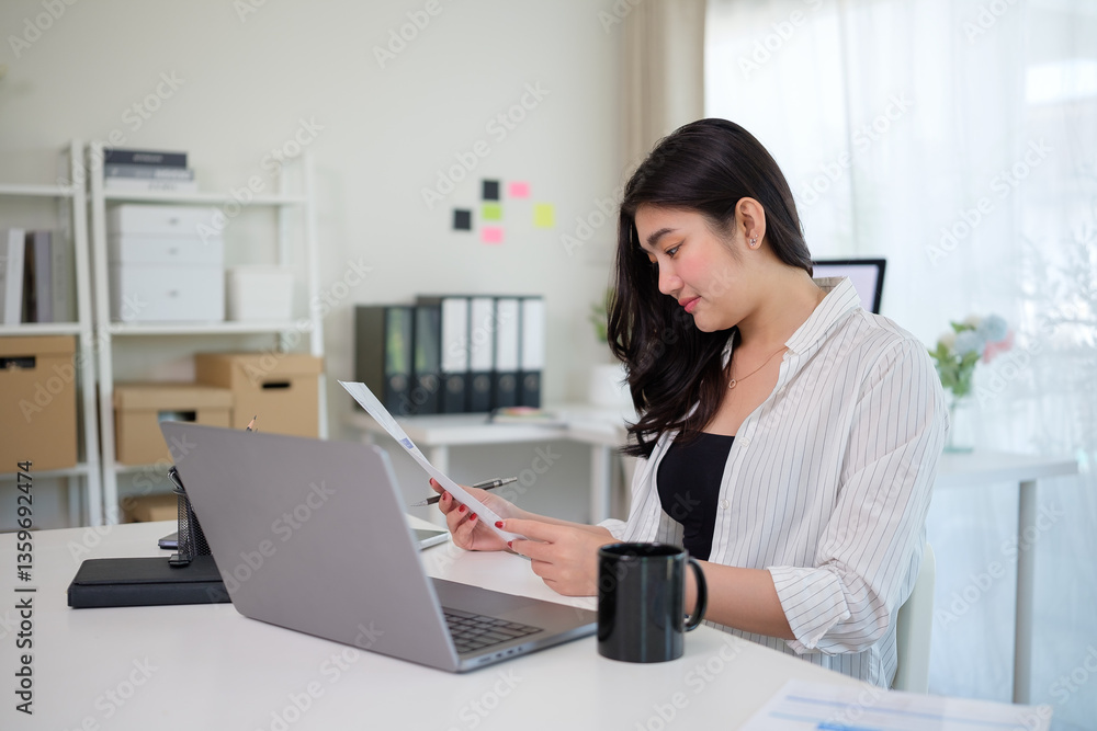 Young entrepreneur sitting at her desk while analyzing financial reports in a modern office. Young entrepreneur sitting at her desk while analyzing financial reports in a modern office.