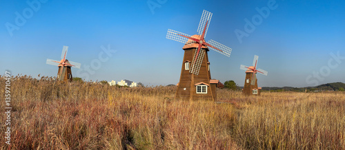 Wallpaper Mural Three Wooden Windmills in a Golden Field Under a Clear Blue Sky Torontodigital.ca