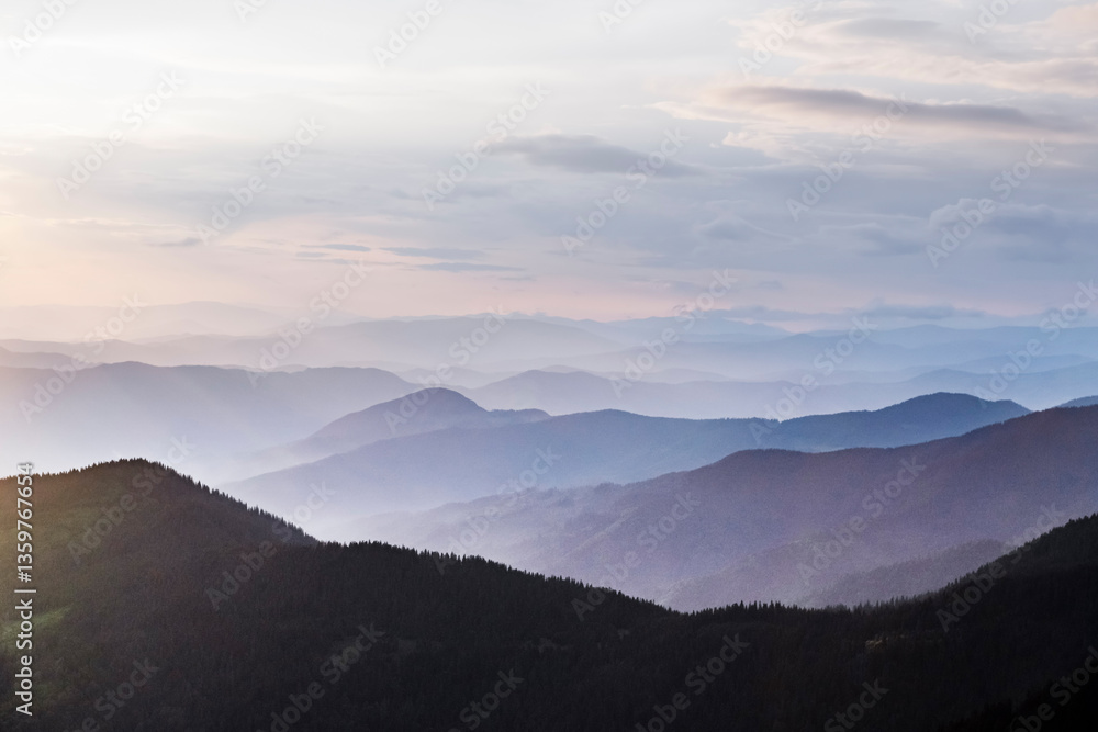Obraz premium Layers of blue mountains stretching into the horizon, glowing under the warm sunrise light. Spring mountains. Landscape photography