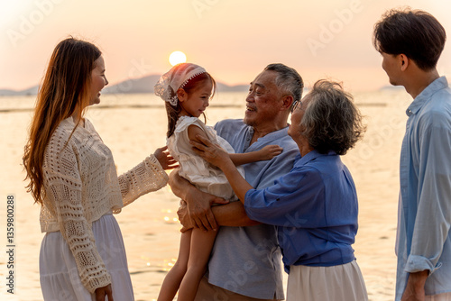 Happy family beach vacations.Group of multi generation family little girl with parents and grandparents relax and enjoy together on the beach.