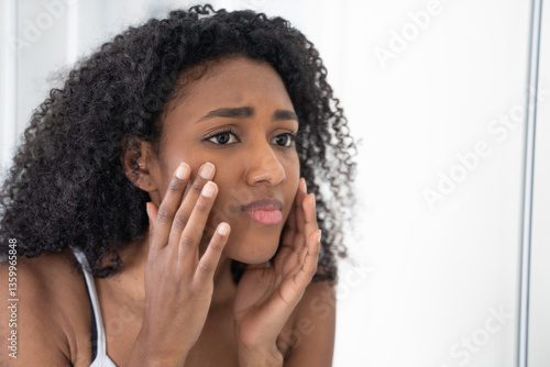 One black woman worried in front of mirror