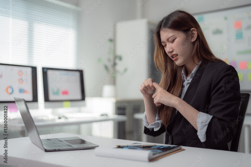 Businesswoman experiencing wrist pain while working on a laptop in an office setting, highlighting issues related to carpal tunnel syndrome and office syndrome within health care contexts Businesswoman experiencing wrist pain while working on a laptop in an office setting, highlighting issues related to carpal tunnel syndrome and office syndrome within health care contexts