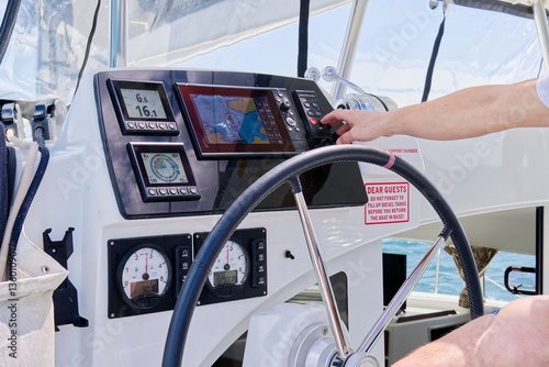 Foto The image shows a modern yacht s dashboard control panel with a hand on the steering wheel