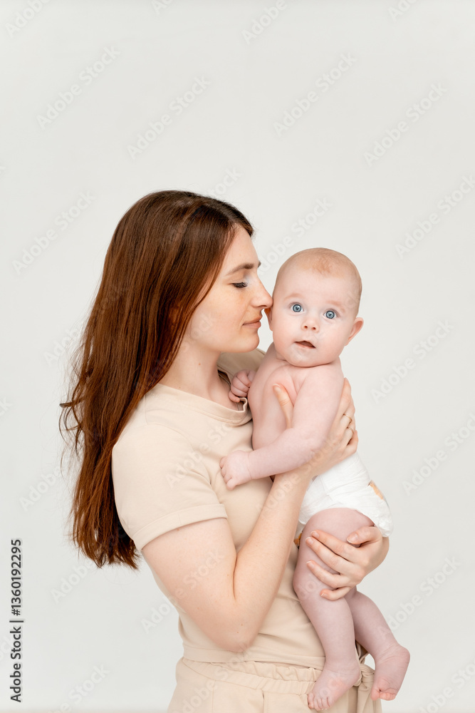 a mother with a baby on a white isolated background, a place for text, a young mother gently hugs her little child, a girl in diapers, maternal love and care a mother with a baby on a white isolated background, a place for text, a young mother gently hugs her little child, a girl in diapers, maternal love and care
