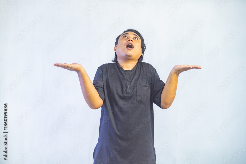 Asian Muslim men pointing to the copy space beside her, isolated by white background. Ramadan and Eid Mubarak concept.