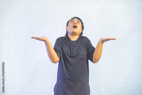 Asian Muslim men pointing to the copy space beside her, isolated by white background. Ramadan and Eid Mubarak concept.