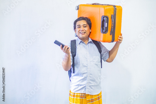 Obraz na płótnie Portrait Asian muslim man carrying suitcase while holding mobile phone with copy space inside. Concept Going home for Eid Mubarak. Isolated image on white background w salonie