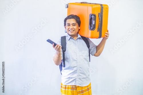 Obraz na płótnie Portrait Asian muslim man carrying suitcase while holding mobile phone with copy space inside. Concept Going home for Eid Mubarak. Isolated image on white background w salonie