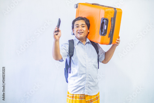 Obraz na płótnie Portrait Asian muslim man carrying suitcase while holding mobile phone with copy space inside. Concept Going home for Eid Mubarak. Isolated image on white background w salonie
