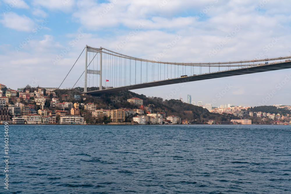 Fototapeta premium View of Sultan Mehmed Fatih Bridge and the embankment of the European part of Istanbul from the water area of the Bosphorus on a sunny day, Istanbul, Turkey