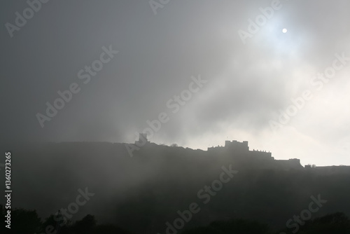 Obraz na płótnie Sun visible through clouds and fog over silhouette of Dover castle w salonie