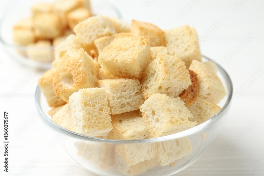 Delicious crispy croutons on white wooden table, closeup Delicious crispy croutons on white wooden table, closeup