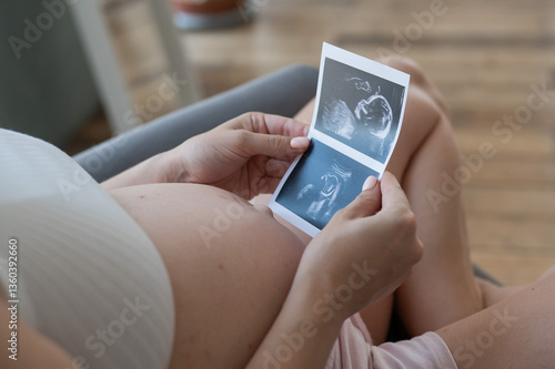 Photography Pregnant woman holding baby ultrasound photo.