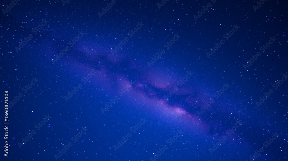 Fototapeta premium Cosmic galaxy swirling in purple hues against a starry night sky 