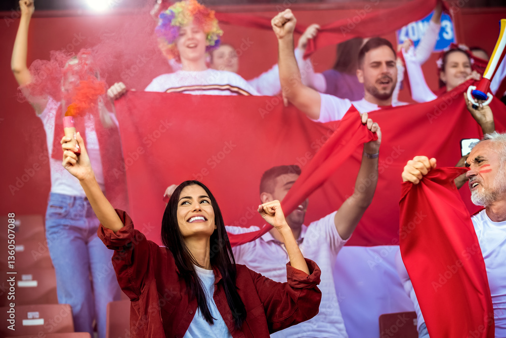 Fototapeta premium Sport fans lit torches in the stadium at the game. Red colors, flags, stadium.