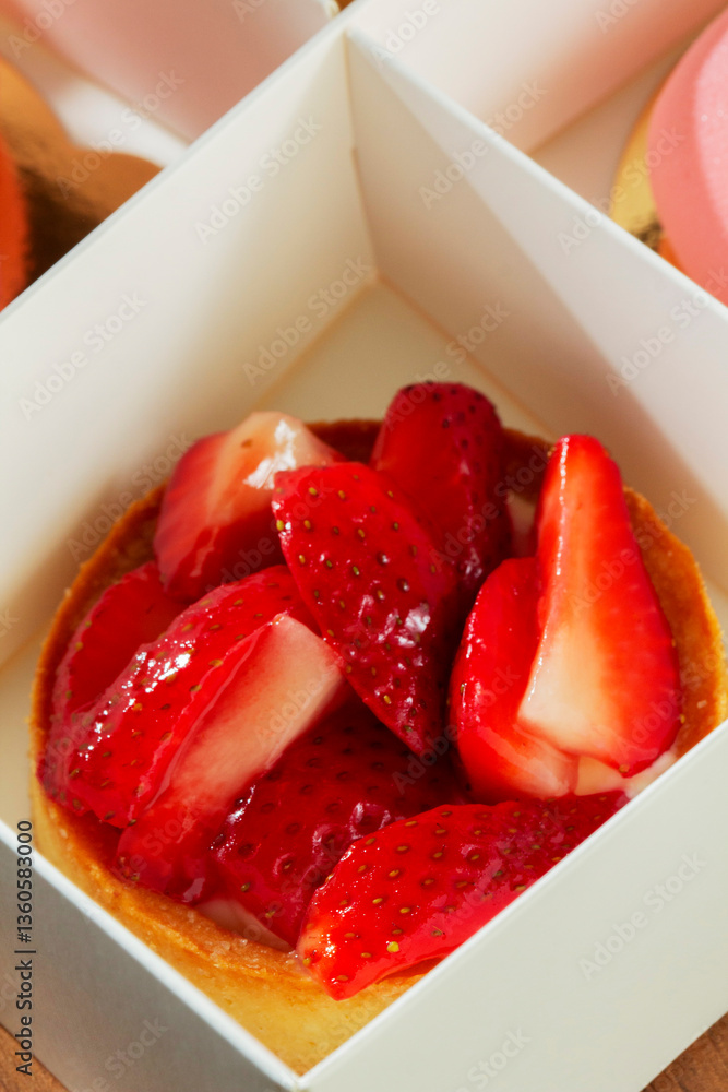 Gift set of heart-shaped mousse cakes and shortbread baskets with strawberries in a box.