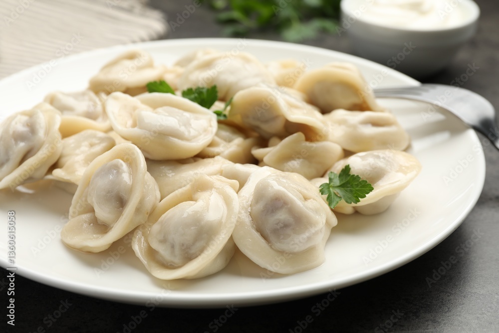 Delicious dumplings with fresh parsley served on grey table, closeup Delicious dumplings with fresh parsley served on grey table, closeup
