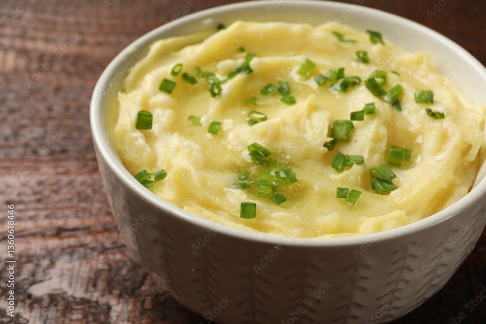 Tasty mashed potato with green onion in bowl on wooden table, closeup Tasty mashed potato with green onion in bowl on wooden table, closeup