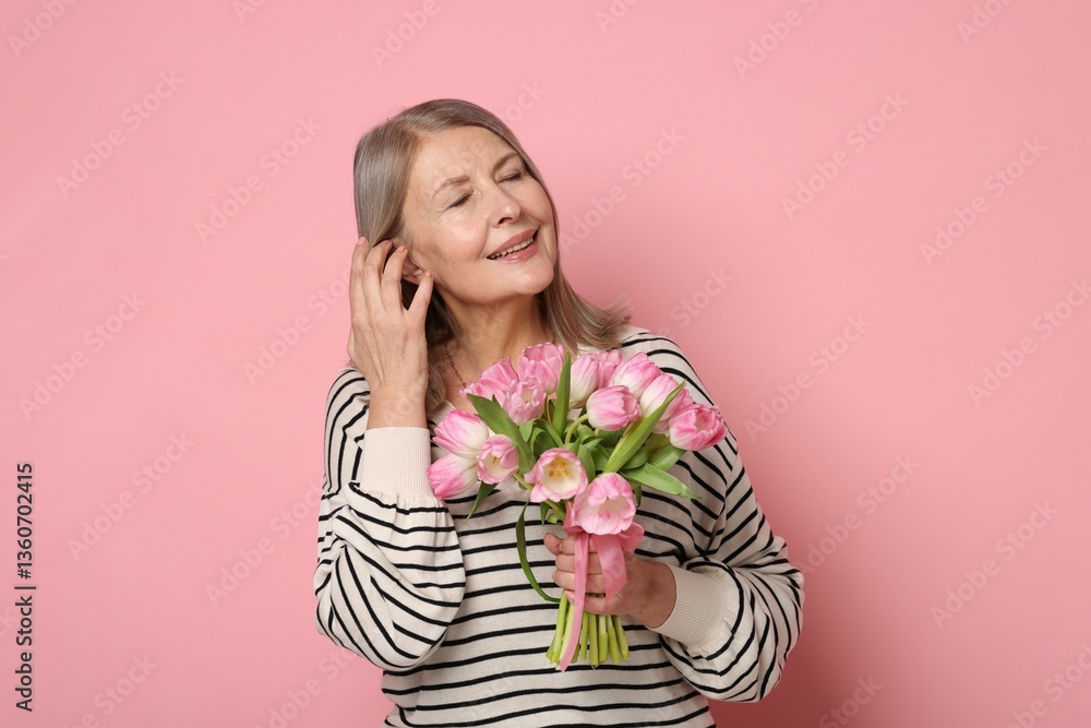 Smiling woman with bouquet of tulips on pink background Smiling woman with bouquet of tulips on pink background