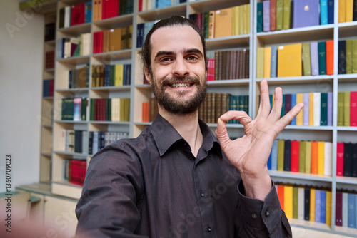 Obraz na płótnie Selfie photo portrait young 30s positive man inside library showing ok gesture w salonie