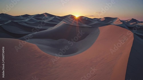 Sunset transforms sand dunes with golden light and dramatic shadows in desert landscape