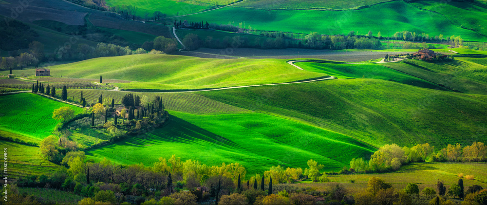 Fototapeta premium Panoramic view of a road and some farmhouses in the countryside around Montepulciano, Tuscany