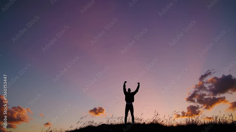 Silhouette of a person with raised fist against a colorful sunset sky. Low-angle shot emphasizes triumph. Ideal for motivational video themes. Live desktop wallpaper. Silhouette of a person with raised fist against a colorful sunset sky. Low-angle shot emphasizes triumph. Ideal for motivational video themes. Live desktop wallpaper.