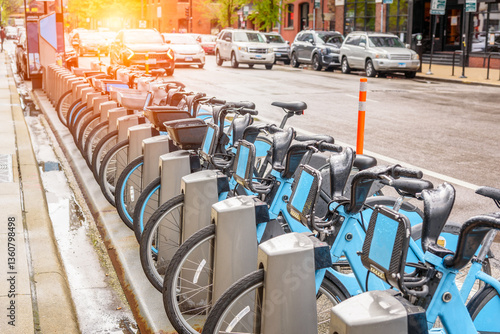 Row of share-use bicycles at a docking station along a street in downtown Chicago after a spring thunderstorm