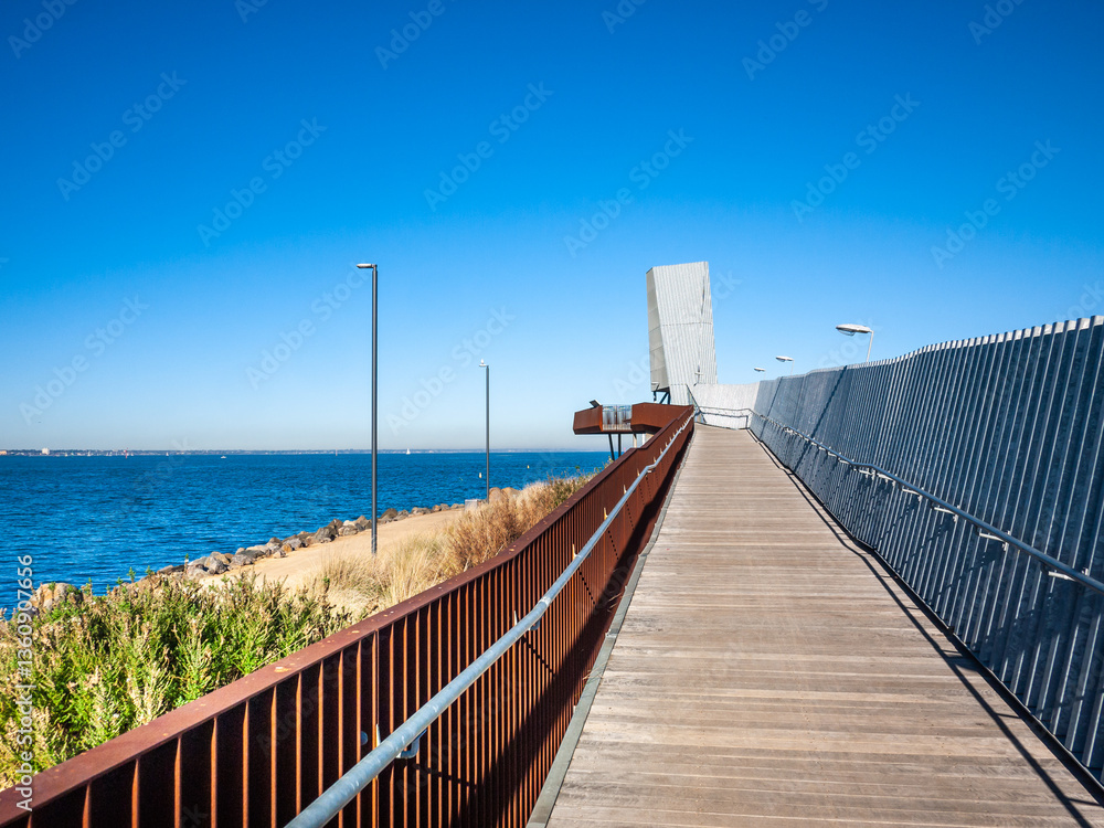 Naklejka premium Pedestrian boardwalk and elevated viewpoint at Sandridge Lookout. The platform offers visitors a view of Melbourne’s skyline in Australia.