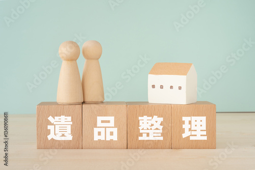 遺品整理と書かれたブロック、人形、家の置き物