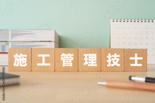 施工管理技士と書かれたブロックが置かれたデスク