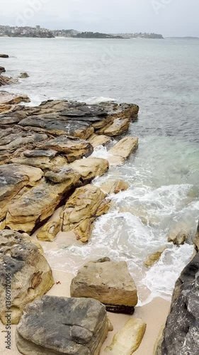 water wave hitting rocks on the shore near Sydney Australia