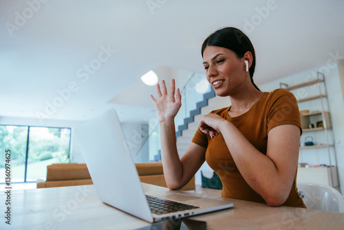 Bilde på lerret Woman sitting in living room using laptop looking at cam talk by video call with business friend relatives, head shot