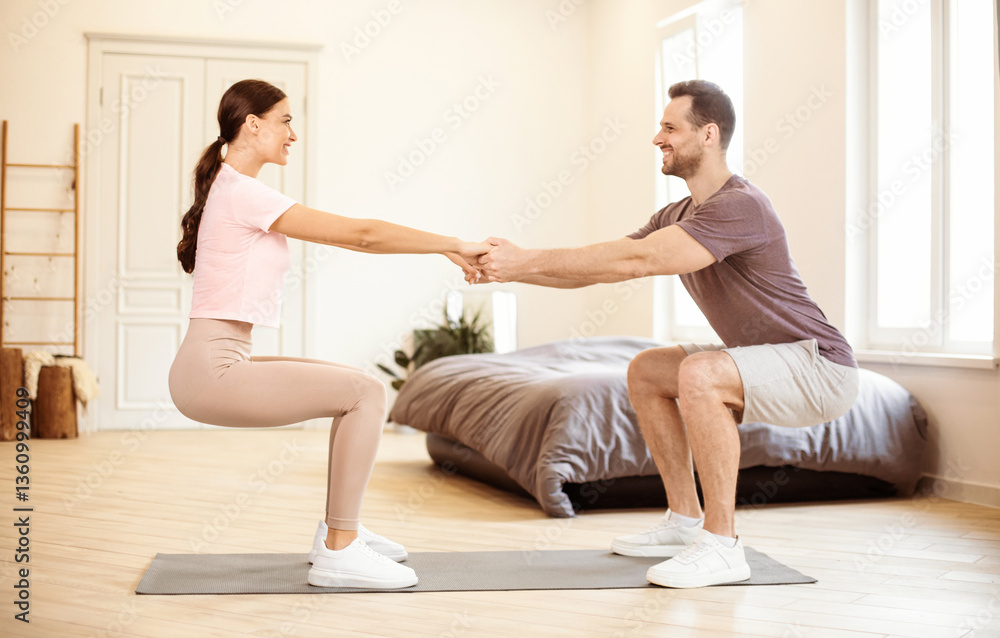 Fototapeta premium Family Workout. Husband And Wife Exercising Doing Two-Legged Squat Holding Hands, Training Together At Home. Sporty Lifestyle, Couples Fitness Routine, Yoga Balance Exercise Concept