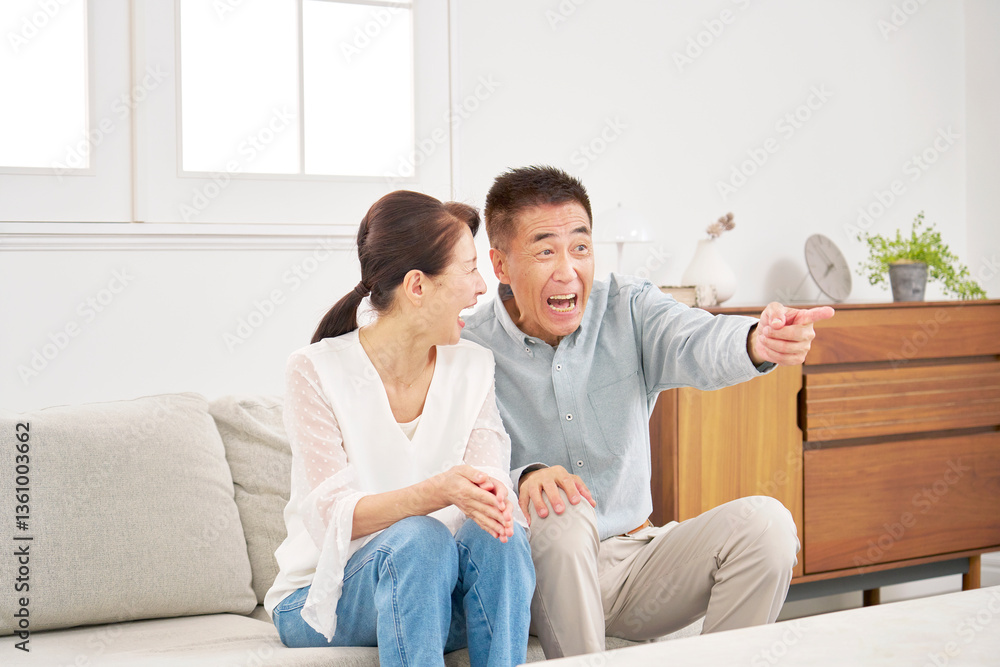 テレビを見るシニアの夫婦 リビング テレビを見るシニアの夫婦 リビング